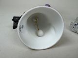 a white cup with a flower in it on a table