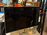 a computer monitor sitting on a desk in a room
