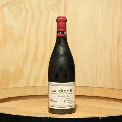 a bottle of wine sitting on top of a barrel