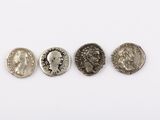 trois pièces romaines, dont l'une représente une tête et l'autre un visage