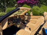 an image of a tan convertible car parked in front of a house