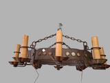 a chandelier made of metal and wood with candles