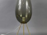an image of a gray glass lamp with a gold tripod base
