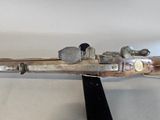 a wooden model of a gun on a black stand