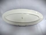 a white plate with a silver rim on a white table