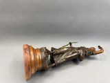 une vieille statue en bronze représentant un homme allongé sur un socle en bois