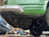 a green car that is parked on the side of the road