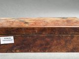 an old wooden box with a label on it sitting on a table