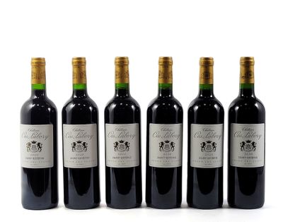 six bottles of wine are lined up in a row on a white surface