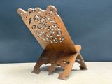 a small wooden chair with a carved back and seat