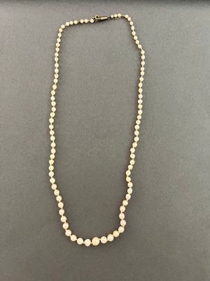 a white pearl necklace with a gold clasp