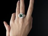 la main d'une femme, sur laquelle se trouve une bague et au milieu de laquelle on voit le signe de la paix