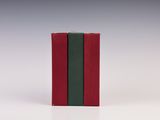 deux livres, un rouge et un vert, posés sur une surface blanche