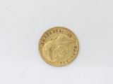 a gold coin on a white surface with a white background