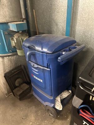 une poubelle bleue posée à côté d'une poubelle noire