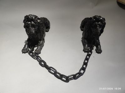 deux chiens noirs attachés à des chaînes posées sur une table
