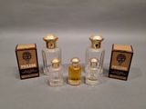 three bottles of perfume and a box of perfume on a table