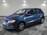 La Volkswagen Polo bleue est garée sur un sol carrelé à damier.