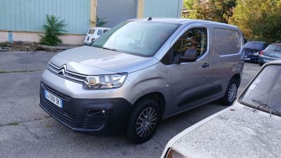 une camionnette argentée garée sur un parking à côté d'autres voitures