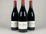 three bottles of red wine sitting next to each other on a table