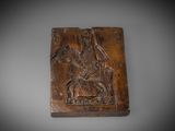 une plaque en bois sculpté représentant un homme à cheval