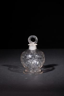 an old glass bottle with a handle on a black surface
