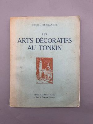 un vieux livre posé sur une table à côté d'un mur