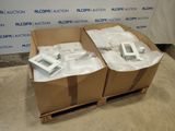 deux cartons contenant du matériel électronique posés sur une palette en bois