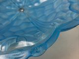 a blue glass bowl sitting on a white table