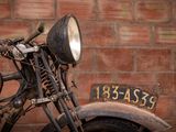 a old motorcycle that is parked in front of a brick wall