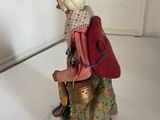 a figurine of a woman with a backpack on a table