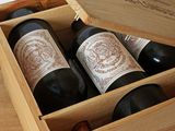 trois bouteilles de vin dans un coffret en bois sur une table