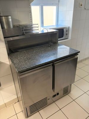 a stainless steel counter top in a kitchen with a microwave on it