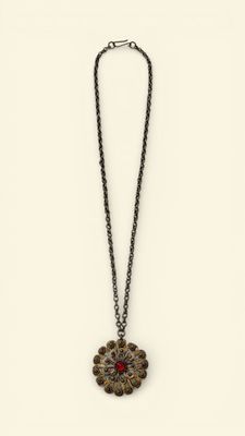 a necklace with a flower design on a chain