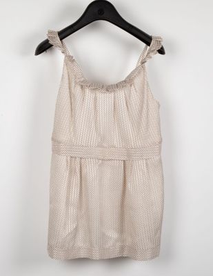 a white top with a ruffled neckline hanging on a hanger