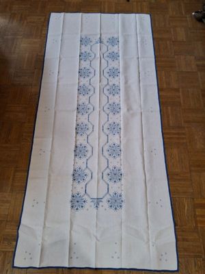 une photo d'un chemin de table posé sur un parquet