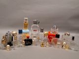 de nombreux flacons de parfum de styles variés posés sur une surface blanche