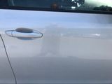a white car that has a broken door handle on it