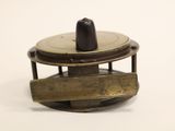 a small brass object on a white surface