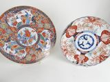 two japanese plates, one with a floral design and one with a bird design