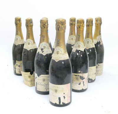 six bottles of champagne are lined up in a row on a white surface