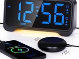 un réveil noir posé à côté d'un chargeur sans fil