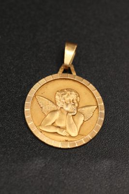 un gros plan d'une médaille d'or sur laquelle figure un ange