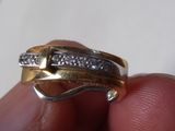une personne tenant dans sa main une bague en or sertie de diamants