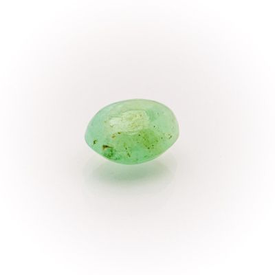 a close up of a green stone on a white surface