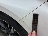 someone is holding a ruler in front of a car with the word auto written on it