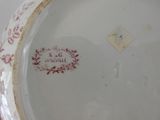 a close up of a plate with a red design on it