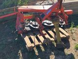 une machine rouge posée sur une palette dans l'herbe