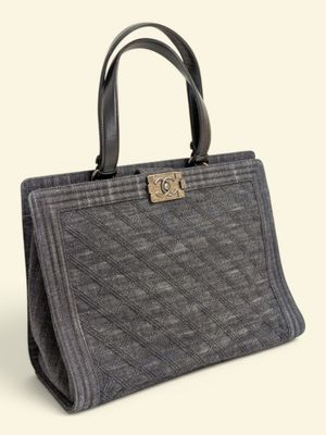 un sac à main gris muni d'un fermoir métallique sur la poignée