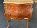 une petite commode en bois avec un plateau en marbre